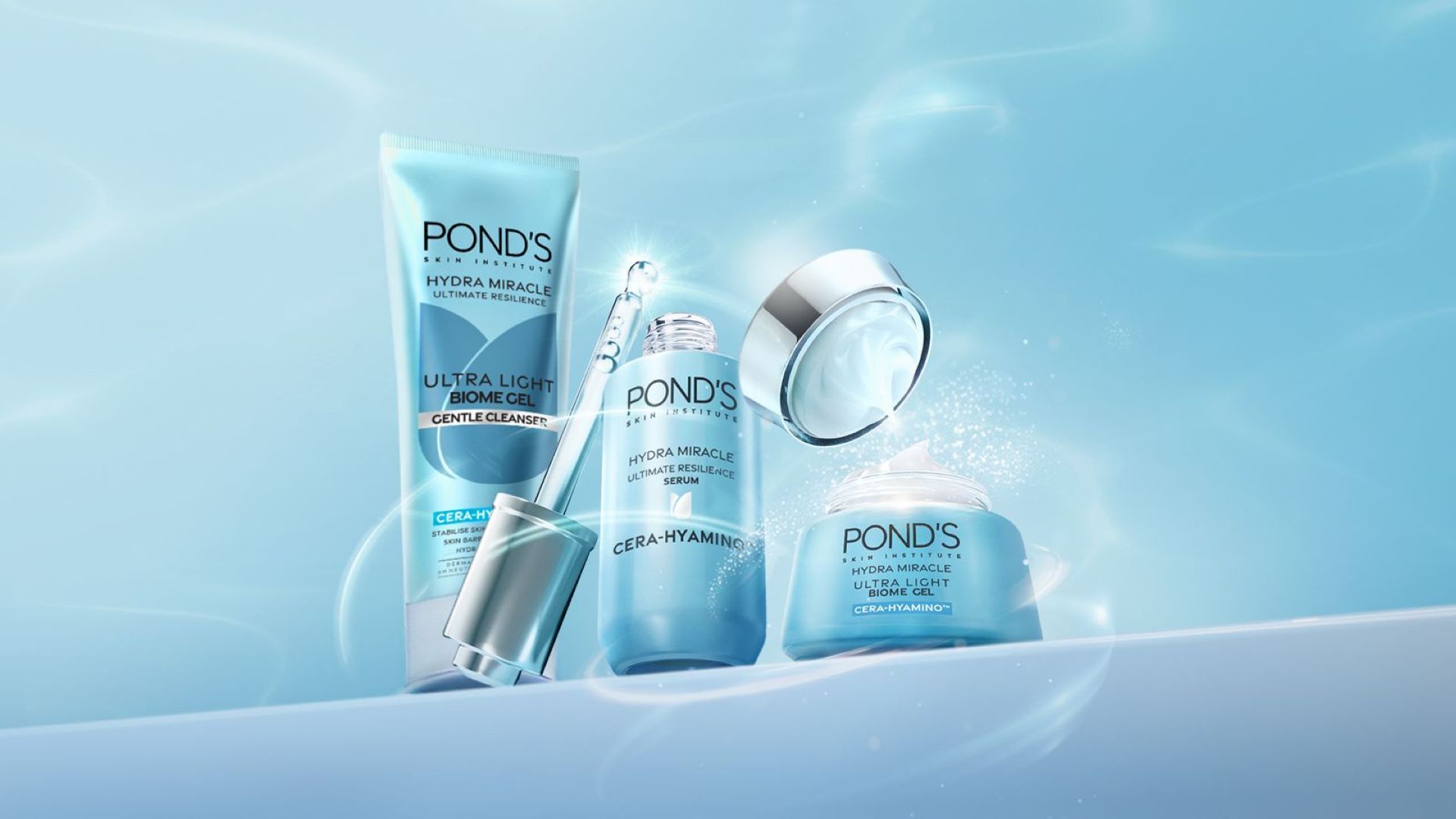 Ba sản phẩm Pond’s Hydra Miracle Ultra Light. Tông xanh phối bạc. Một chai serum đang mở nắp, phần ống nhỏ giọt hiện rõ.