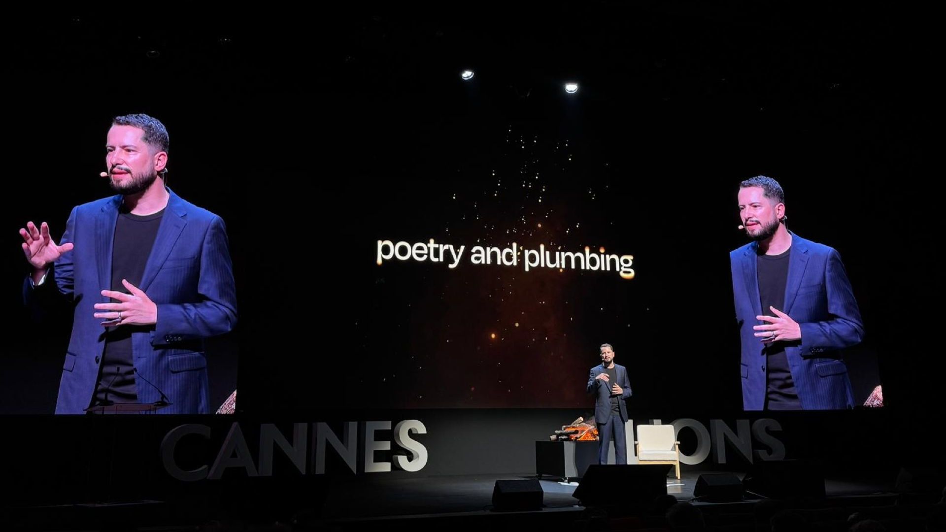 Leandro Barreto trình bày trên sân khấu Cannes Lions 2026, phía sau là màn hình với dòng chữ “Poetry and Plumbing”