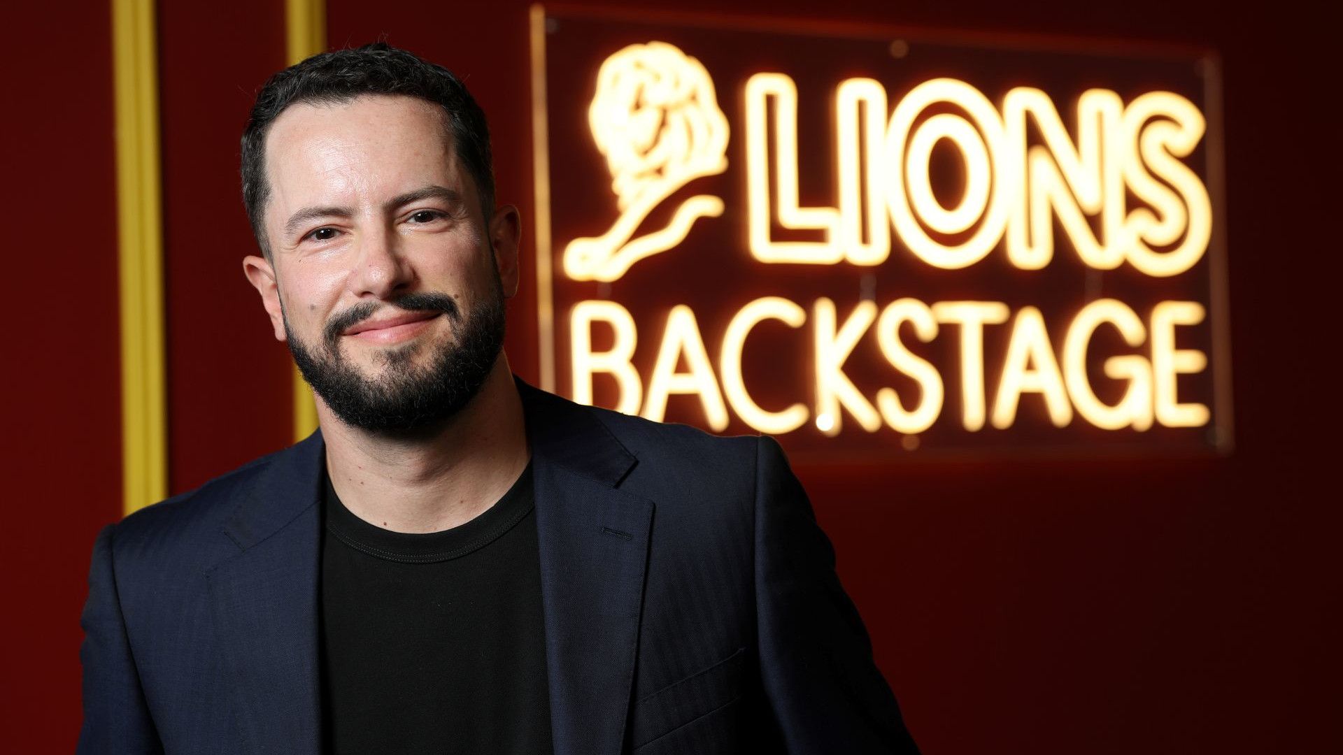 Leandro Barreto tại Cannes Lions 2026, đứng trước bảng đèn neon “Lions Backstage”.