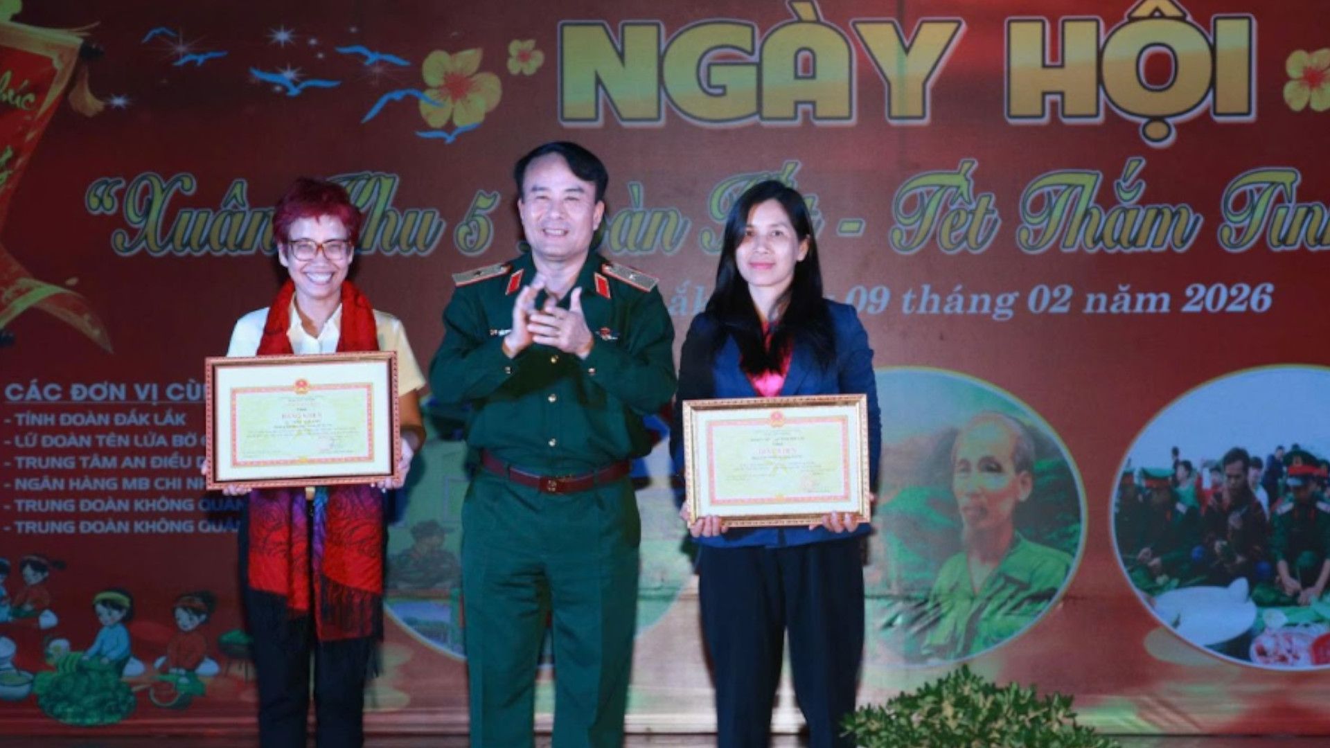 Đại diện Dự án “Một vòng tay ấm” - Nhà báo Trần Mai Anh (áo trắng) và Phóng viên Ái Linh, Phòng thời sự, Trung tâm truyền hình Việt Nam khu vực miền Trung Tây Nguyên nhận Bằng khen do Thiếu tướng Trần Minh Trọng- Ủy viên Ban Thường vụ Đảng uỷ - Phó Chính uỷ Quân khu 5 trao tặng